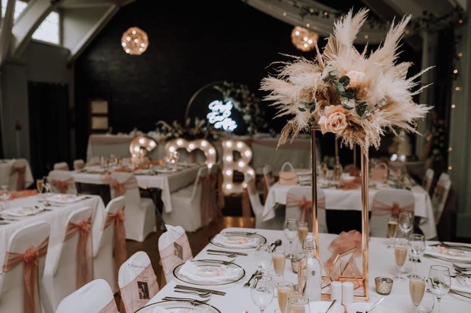 Boho wedding reception with tall pampas grass centrepieces, rose gold stands, illuminated letters and blush chair sashes at Holt Fleet, wedding decor hire Worcestershire