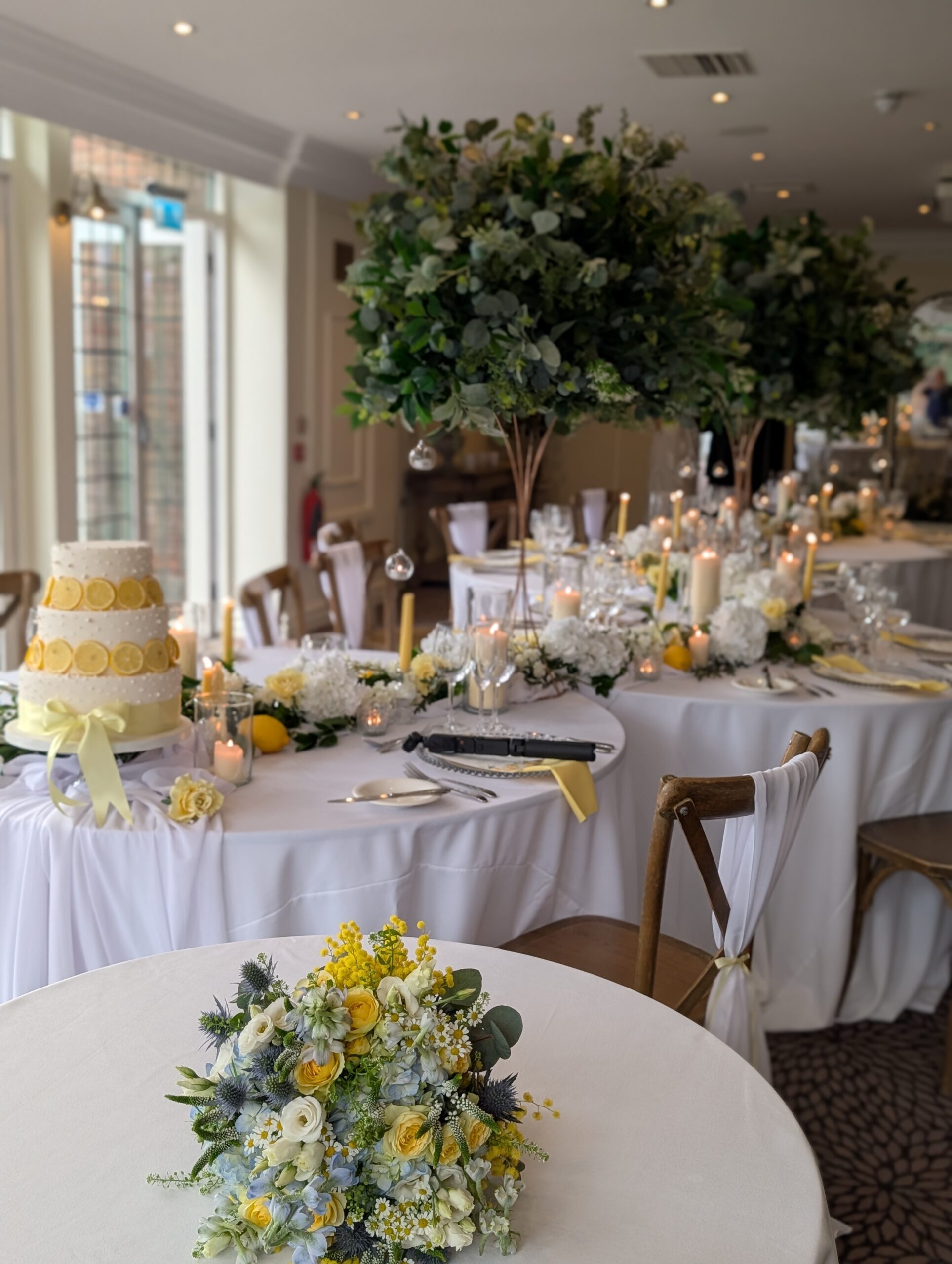 Hogarths Stone Manor wedding reception decor with tall floral centrepieces, candles, lemon theme cake and elegant table styling