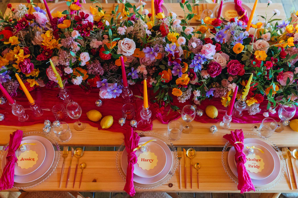 Wedding decor table styling at Elmbridge Farm featuring elegant floral centrepieces, candles and coordinated reception table decorations in a rustic barn venue.