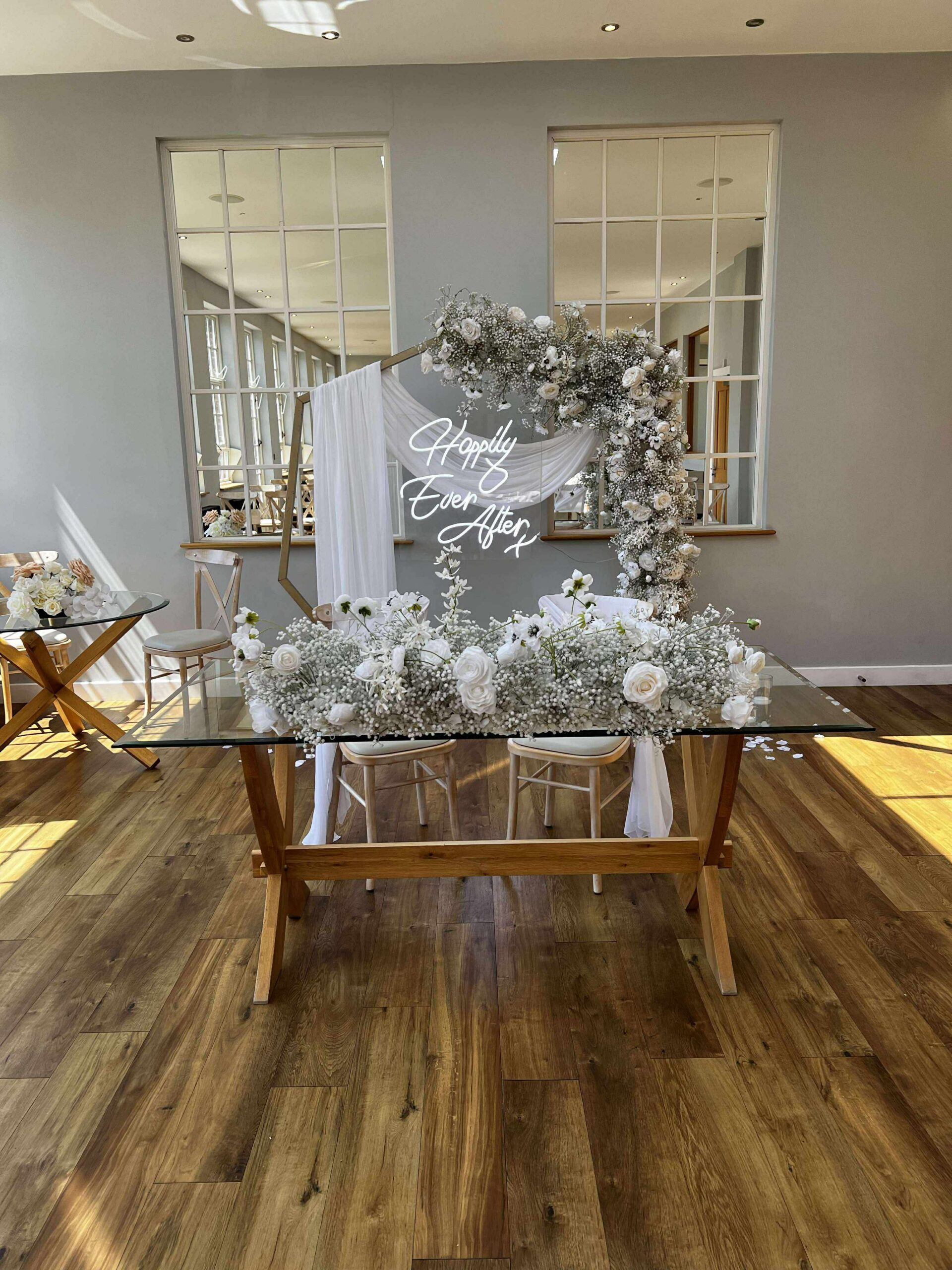 Ceremony table with floral arrangement and hexagon arch backdrop at Bredenbury Court Barns