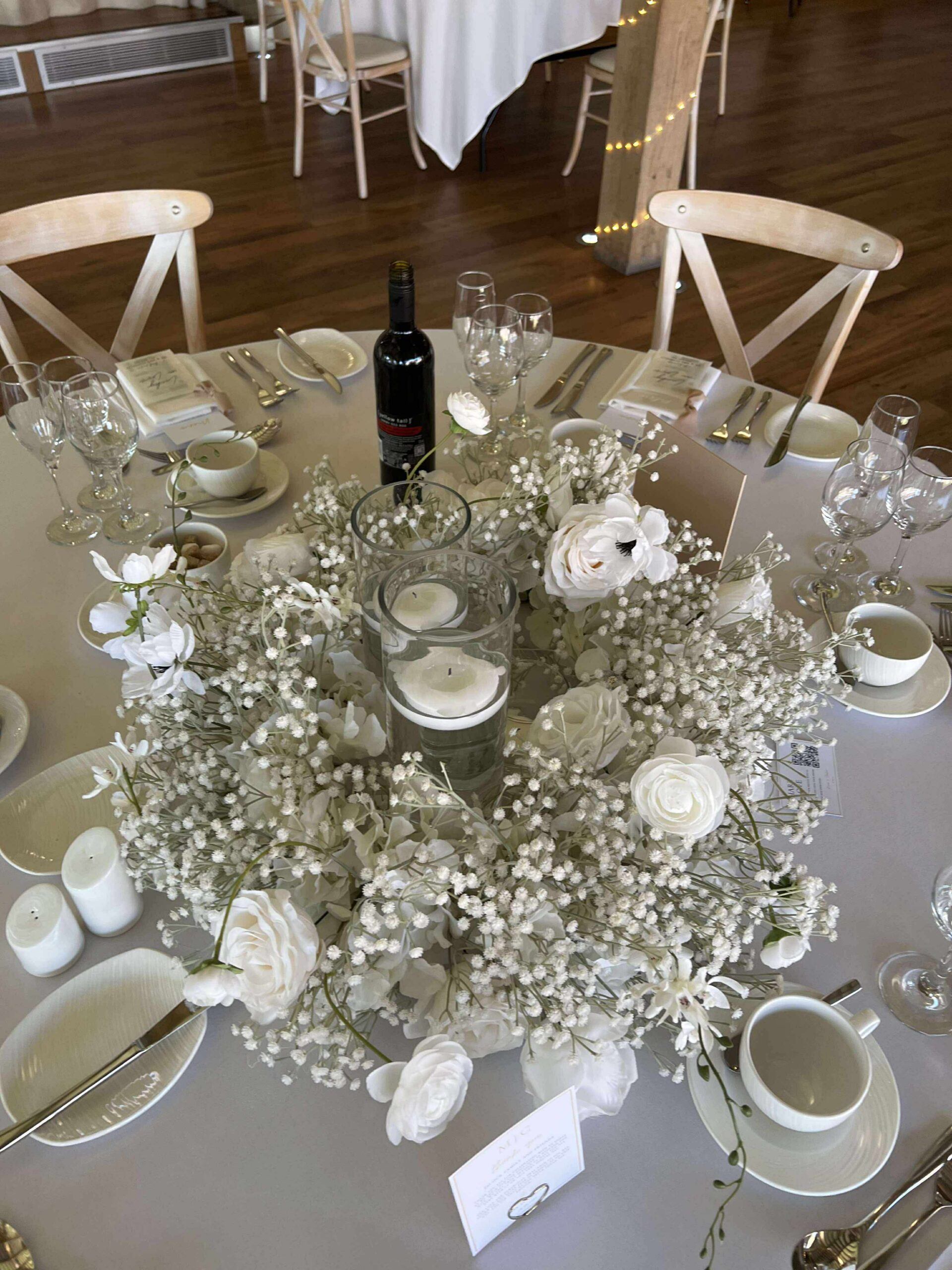 White floral ring centrepiece with candles and gypsophilia on wedding table at Bredenbury Court Barns